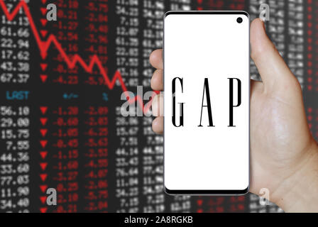 Il logo della società pubblica Gap Inc. visualizzata su uno smartphone. Stock negativi sullo sfondo del mercato. Credito: PIXDUCE Foto Stock