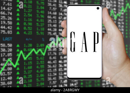 Il logo della società pubblica Gap Inc. visualizzata su uno smartphone. Positivo del mercato azionario sfondo. Credito: PIXDUCE Foto Stock