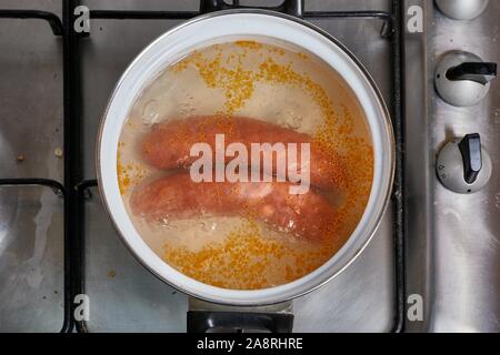 Salsicce di ebollizione sulla stufa Foto Stock