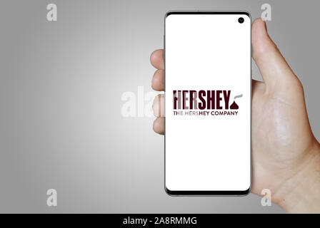 Il logo della società pubblica la Hershey Company visualizzata su uno smartphone. Sfondo grigio. Credito: PIXDUCE Foto Stock