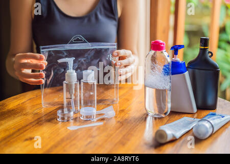 Kit da viaggio per il trasporto di prodotti cosmetici su un aereo. I prodotti cosmetici sono pronti per essere versata in bottiglie piccole Foto Stock