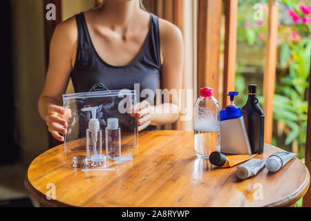 Kit da viaggio per il trasporto di prodotti cosmetici su un aereo. I prodotti cosmetici sono pronti per essere versata in bottiglie piccole Foto Stock