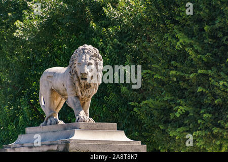 Lion scultura con cespugli di verde sullo sfondo Foto Stock