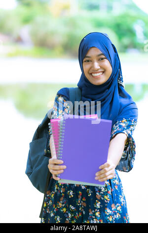 Ritratto di bella felice adolescente islamico musulmani università asiatiche ragazza con lei i libri per la conoscenza e la saggezza concetto Foto Stock