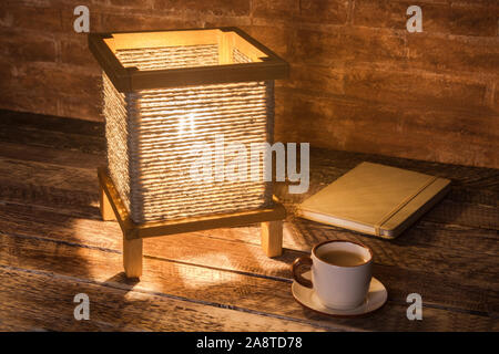 Tazza di caffè, notebook e vintage lampada da tavolo. Tempo per rilassarsi. Foto Stock