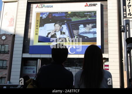 Domenica. Decimo Nov, 2019. La gente guarda un grande schermo di radiodiffusione imperatore giapponese Naruhito intronizzazione della parata in Tokyo, Giappone, domenica 10 novembre, 2019. Credito: Hiroyuki Ozawa/AFLO/Alamy Live News Foto Stock