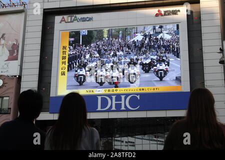 Domenica. Decimo Nov, 2019. La gente guarda un grande schermo di radiodiffusione imperatore giapponese Naruhito intronizzazione della parata in Tokyo, Giappone, domenica 10 novembre, 2019. Credito: Hiroyuki Ozawa/AFLO/Alamy Live News Foto Stock