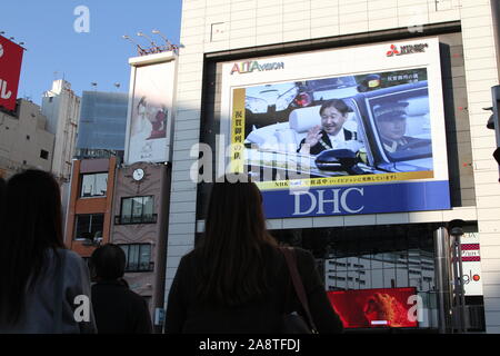 Domenica. Decimo Nov, 2019. La gente guarda un grande schermo di radiodiffusione imperatore giapponese Naruhito intronizzazione della parata in Tokyo, Giappone, domenica 10 novembre, 2019. Credito: Hiroyuki Ozawa/AFLO/Alamy Live News Foto Stock