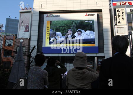 Domenica. Decimo Nov, 2019. La gente guarda un grande schermo di radiodiffusione imperatore giapponese Naruhito intronizzazione della parata in Tokyo, Giappone, domenica 10 novembre, 2019. Credito: Hiroyuki Ozawa/AFLO/Alamy Live News Foto Stock