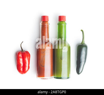 Habanero e peperoncini jalapeno con salsa Tabasco isolati su sfondo bianco. Foto Stock