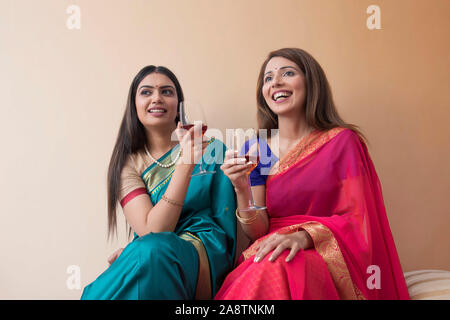 Le donne in saree avente un drink insieme Foto Stock