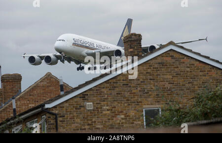 Un basso battenti Singapore Airlines A380 airbus venuta in terra sui tetti in avvicinamento alla pista di atterraggio all' Aeroporto di Heathrow in ottobre 2015. Foto Stock