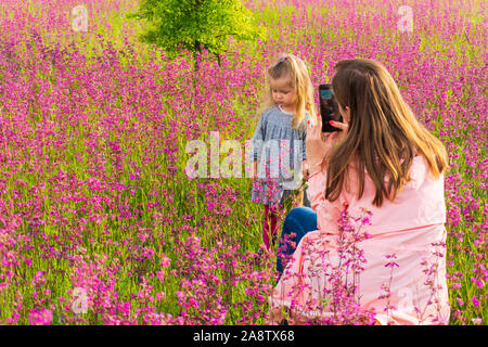 Madre donna fare foto di sua figlia ragazza utilizza lo smartphone Foto Stock