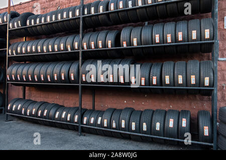 Ordinatamente disposte le righe del pneumatico usato per la vendita in un pneumatico negozio di riparazione su Northern Blvd nel lavaggio, Queens, a New York. Foto Stock