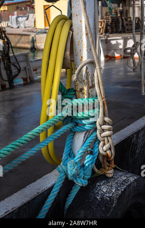 Annodato funi barca appesa in una fila a bordo di una nave Foto Stock