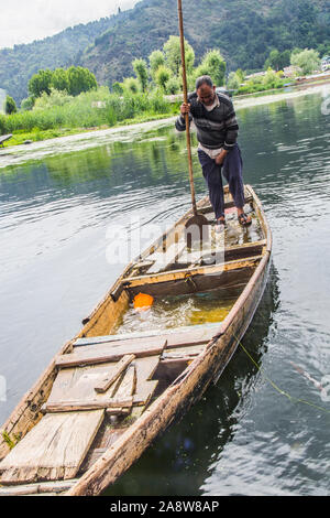 Un vecchio uomo la rimozione di acqua che ha inserito le rotte imbarcazione. Foto Stock