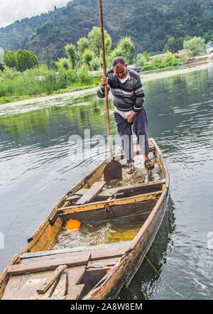 Un vecchio uomo la rimozione di acqua che ha inserito le rotte imbarcazione. Foto Stock