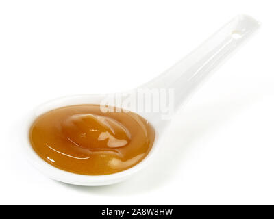 Miele di Manuka in un cucchiaio su sfondo bianco Foto Stock