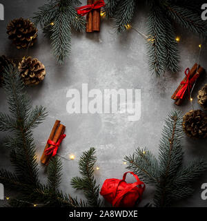 Natale cerchio stile confine con abete rami, coni e bastoncini di cannella e uno spazio nel mezzo di un testo o di un prodotto Foto Stock