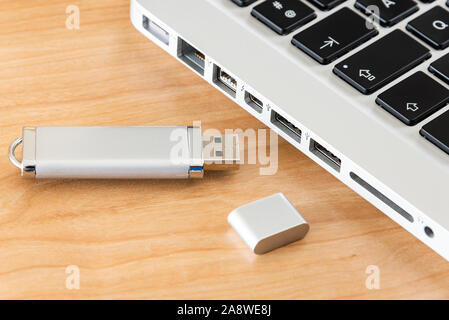 Un argento drive flash USB con un computer portatile. Foto Stock
