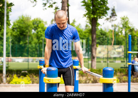 L'uomo facendo bar push up allenamento nel parco Foto Stock