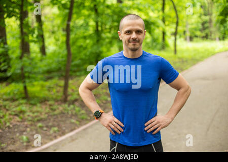 Atleta uomo in blu t-shirt cercando nella fotocamera Foto Stock