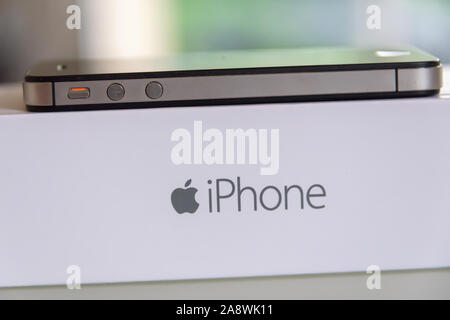 Vista laterale di un Apple iPhone sulla sua casella di colore bianco con il logo Apple Foto Stock