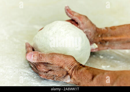 Le mani delle donne rendendo per impastare la pasta per gnocchi Foto Stock