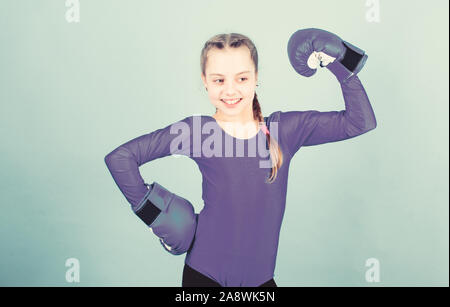 Bambino felice sportivo in guantoni da pugilato. Sport di successo. abbigliamento moda. Dieta Fitness. energia salute. allenamento di piccola ragazza boxer. knockout di punzonatura. Attività dell infanzia. Felice e sportivo. Foto Stock