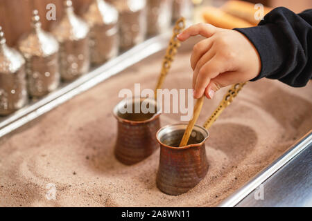 Turca tradizionale caffè servito nella sabbia per ottenere i migliori aromi. Foto Stock