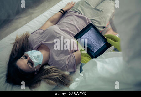 Malati donna sdraiata su una barella in un ospedale Foto Stock