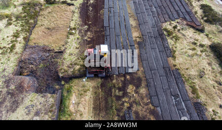 Vista aerea di macchinari la raccolta di torbiera durante l inizio di estate in Irlanda rurale Foto Stock