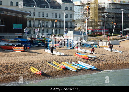 Schede madri per il surf, canoe e barche a vela e la gente si vede sulla spiaggia di Dover in un giorno caldo e soleggiato alla fine di settembre. Foto Stock