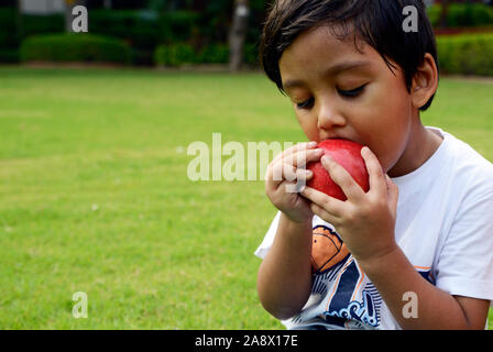 Piccolo Ragazzo di mordere un Apple Foto Stock