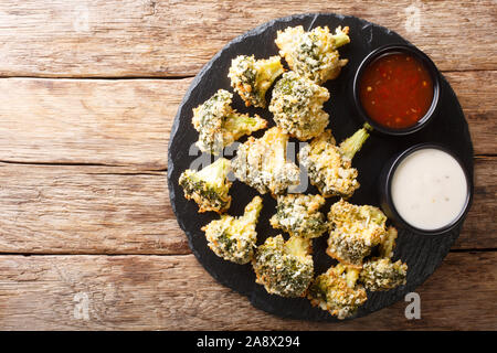 Antipasto sano broccoli bastoni in panatura di formaggio cotto al forno servito con salse sul tavolo. Parte superiore orizzontale vista da sopra Foto Stock