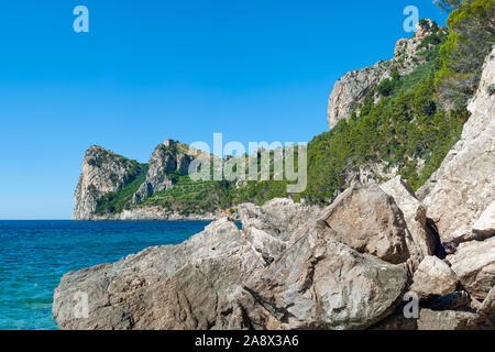 Tre Pizzi di montagna che sorge sulla baia di Nerano di Massa Lubrense, con la Torre di Montalto sul vertice, metà nascosto dalla scogliera sul mare Foto Stock