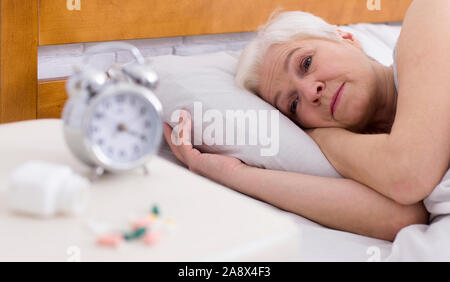 Sconvolto ledy senior con disturbo del sonno giacente a letto Foto Stock