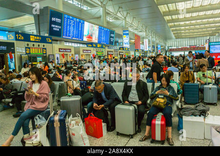 Shanghai, Cina, grande folla di persone in viaggio, pubblico urbano in attesa all'interno, Bullet Train Station, for West, Hangqiao, Minhang District - la più grande stazione ferroviaria in Asia, corridoio affollato, vacanze adolescenziali, schermi delle stazioni, overtourism, cina giovane donna Foto Stock