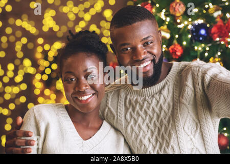 Africa gioiosa giovane tenendo selfie su albero di Natale sfondo Foto Stock