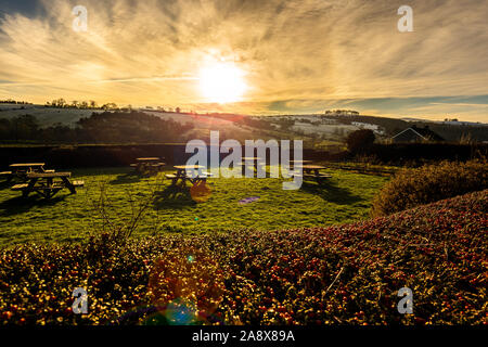 Tramonto su alcuni tavoli da picnic nella gloriosa Derbyshire Peak District National Park, tabelle vuote su un gelido freddo Gennaio sera al tramonto Foto Stock