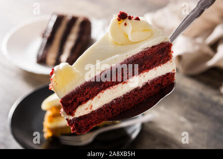 Velluto rosso fetta di torta sul tavolo di legno Foto Stock