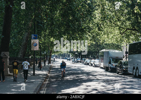 London, Regno Unito - 18 Luglio 2019: vista posteriore dell'uomo passato ciclismo auto nel traffico di Londra, Regno Unito, in estate, motion blur. La bicicletta è un modo popolare di commutare i Foto Stock