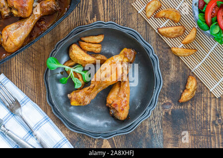 Pollo cosce di pollo disossate in birra allo zenzero con salsa di Spicchi di patate e insalata - vista aerea Foto Stock