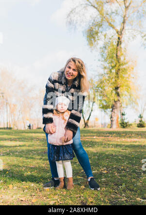 Felice madre e figlia di trascorrere del tempo in autunno il parco della città. Concetto di giorno madre e padre dell'amore. Foto Stock