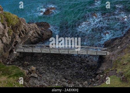 Il Gobbins drammatica ondata di schiantarsi sulla scogliera percorso a piedi sulla East Antrim costa Causeway percorso costiero, County Antrim, Irlanda del Nord Foto Stock