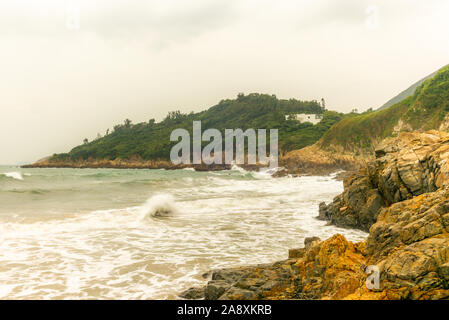 La frantumazione delle onde sugli scogli e spiaggia a grande onda Beach a Hong Kong presso sunrise - 1 Foto Stock