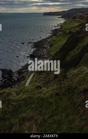 Il Gobbins drammatica ondata di schiantarsi sulla scogliera percorso a piedi sulla East Antrim costa Causeway percorso costiero, County Antrim, Irlanda del Nord Foto Stock