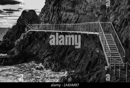 Il Gobbins drammatica ondata di schiantarsi sulla scogliera percorso a piedi sulla East Antrim costa Causeway percorso costiero, County Antrim, Irlanda del Nord Foto Stock