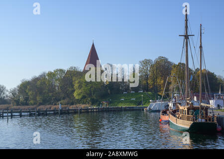 Le navi a vela nel porto di yacht di fronte alla chiesa dell'isola di Poel vicino a Wismar nel Mar Baltico, Germania, cielo blu con spazio di copia Foto Stock