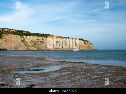 Una vista Verso le scogliere Di Arenaria a Ness Point dalla spiaggia di Robin Hoods Bay North Yorkshire con sabbia e Sea England Regno Unito Foto Stock